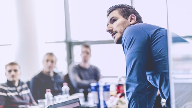 Zakenman die een presentatie op kantoor houdt. Bedrijfsleider die een presentatie aan zijn collega's tijdens vergadering of interne bedrijfstraining geeft, die bedrijfsplannen aan zijn werknemers uitlegt.